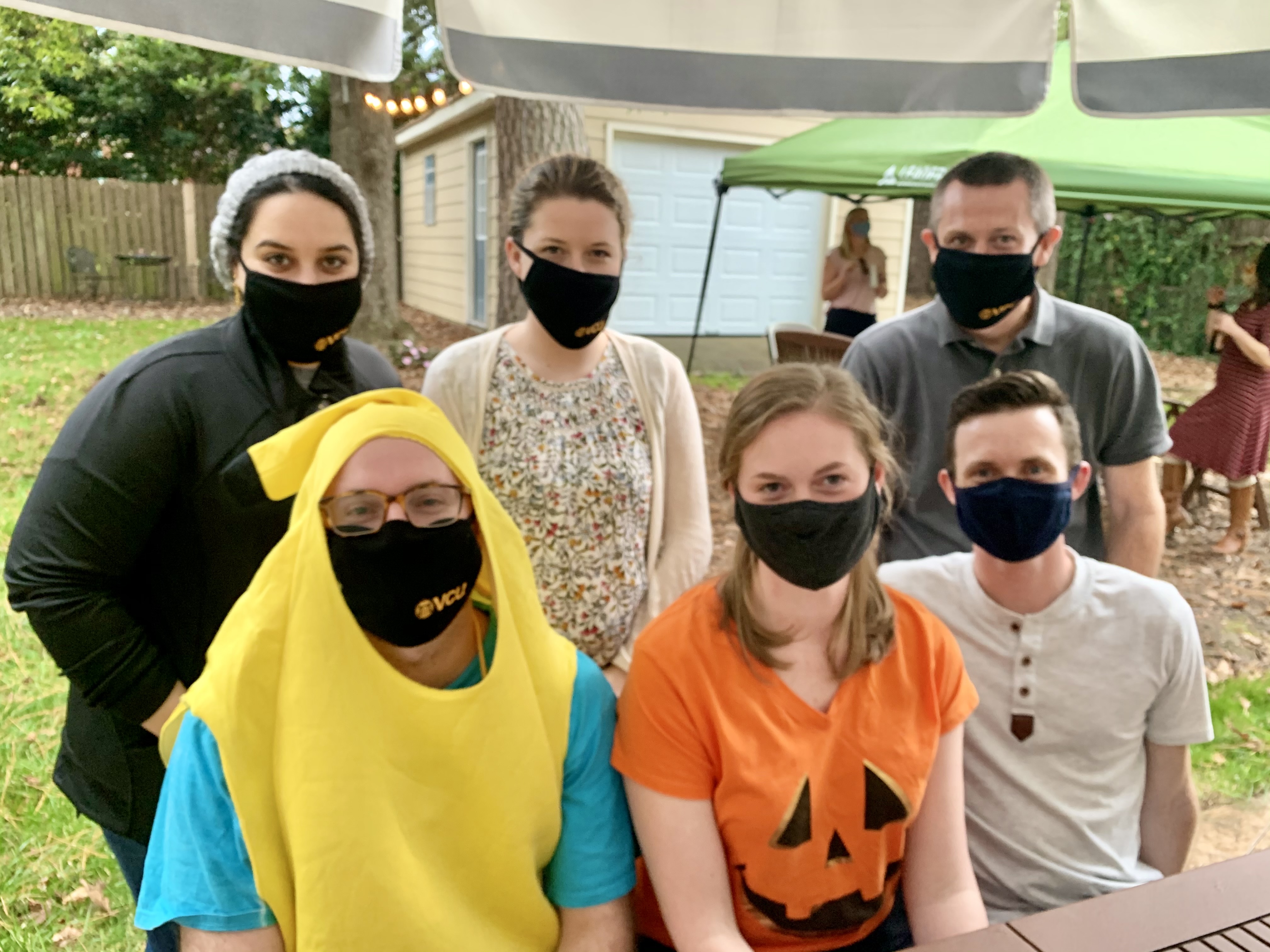 masked residents in Halloween costumes gather for a group photo
