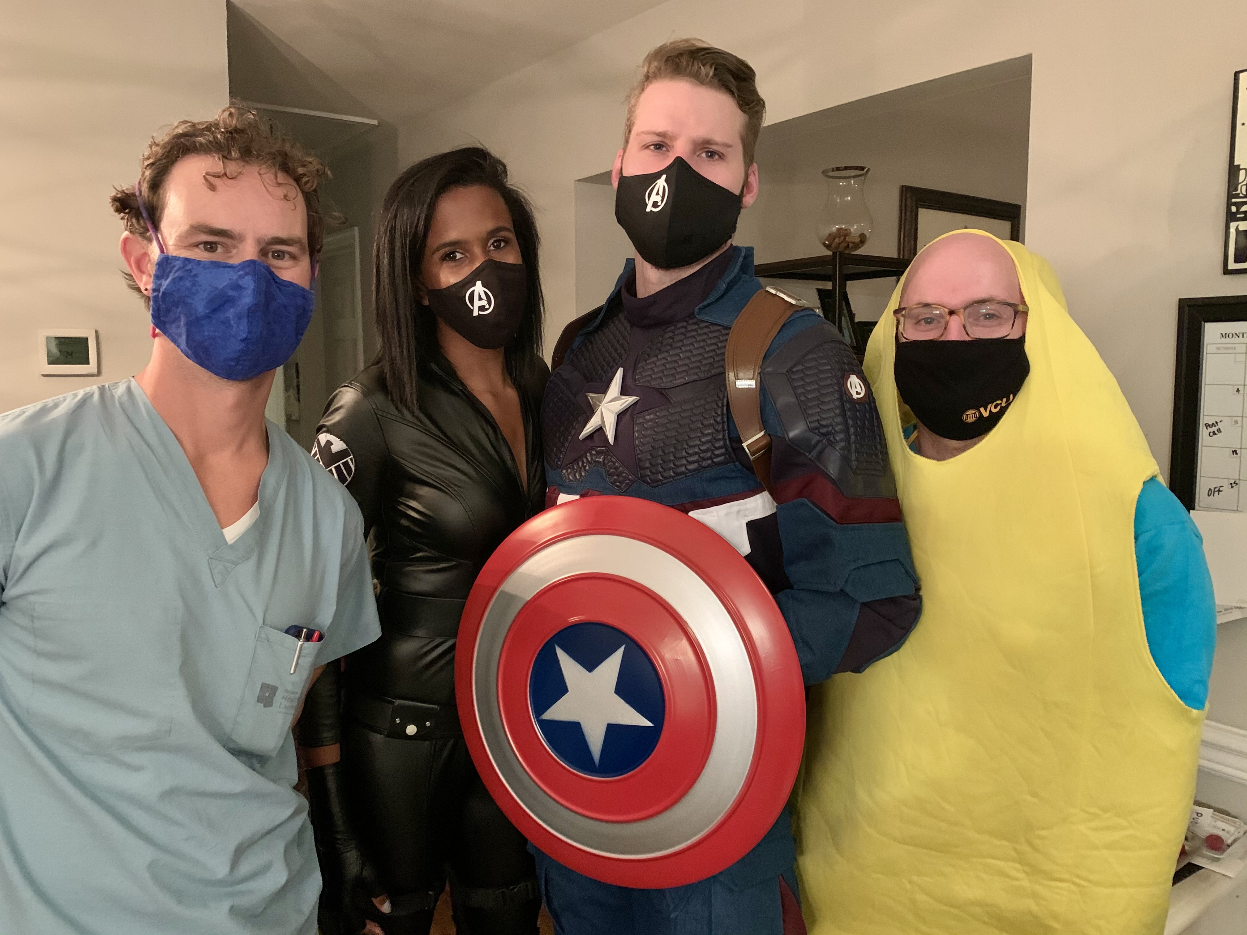 masked residents in Halloween costumes pose for a group pic