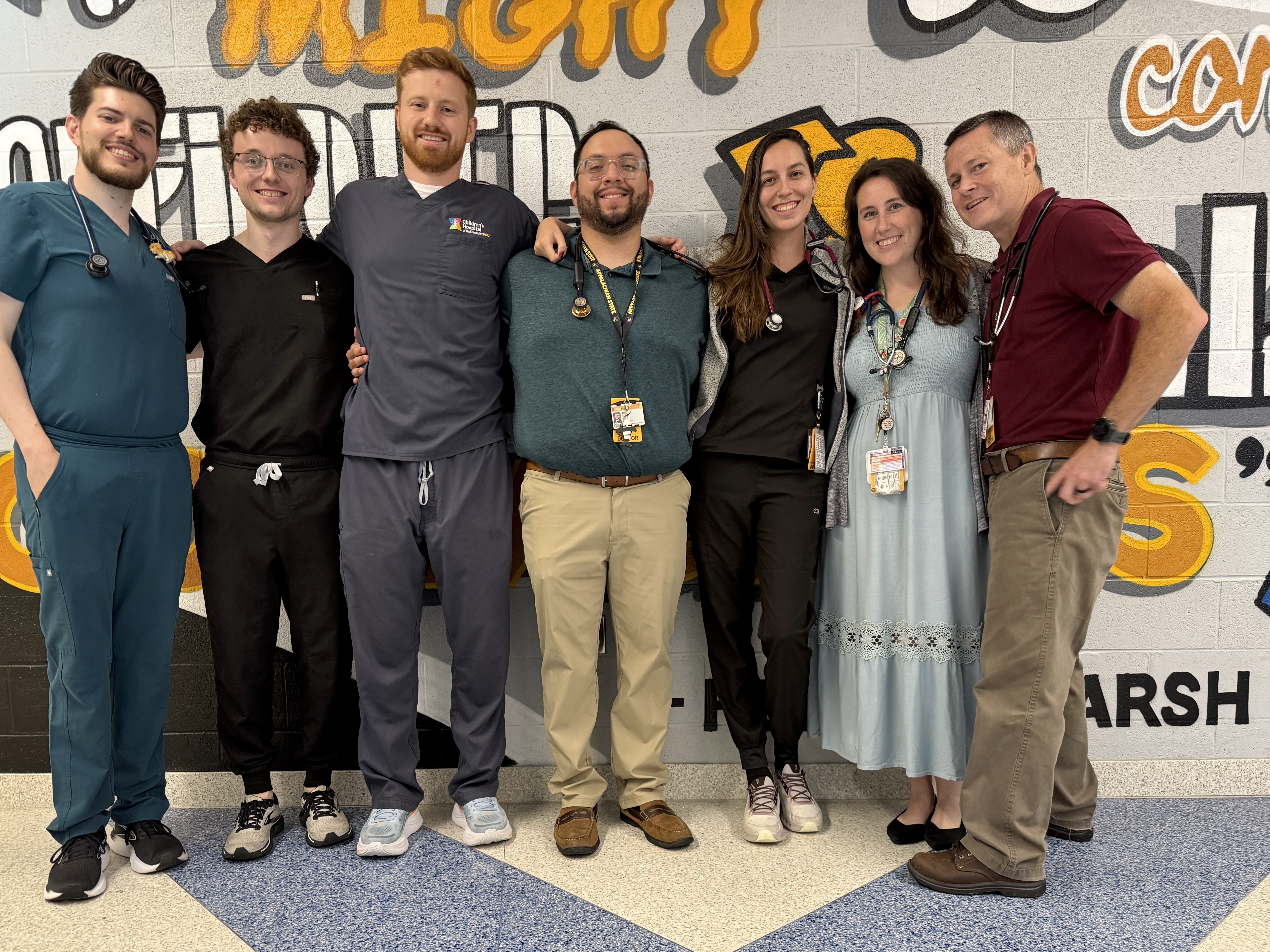 residents pose with the Program Director after doing school physicals at a local Richmond elementary school in collaboration with the Virginia Department of Health