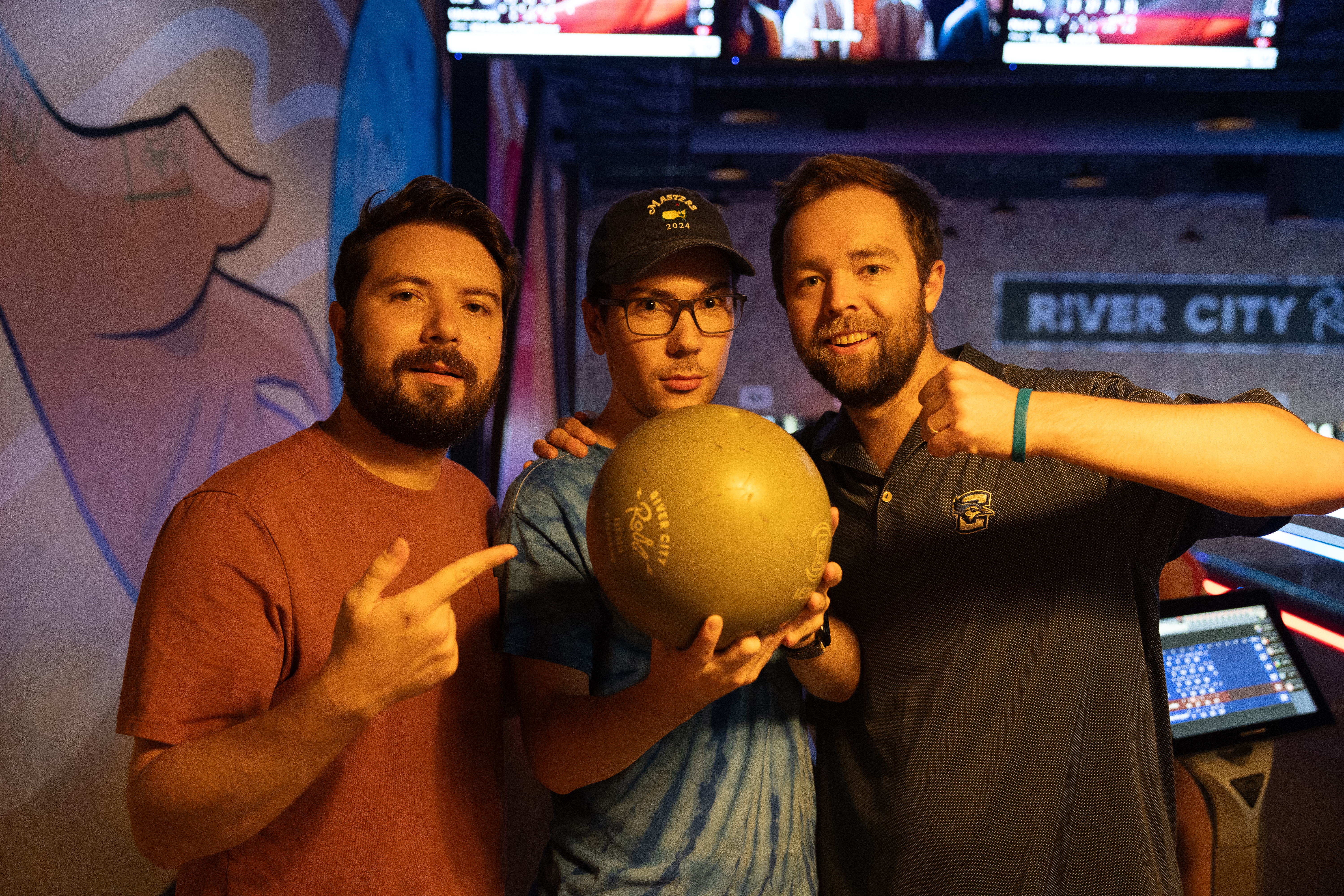 three med-peds residents strike a pose in the bowling alley