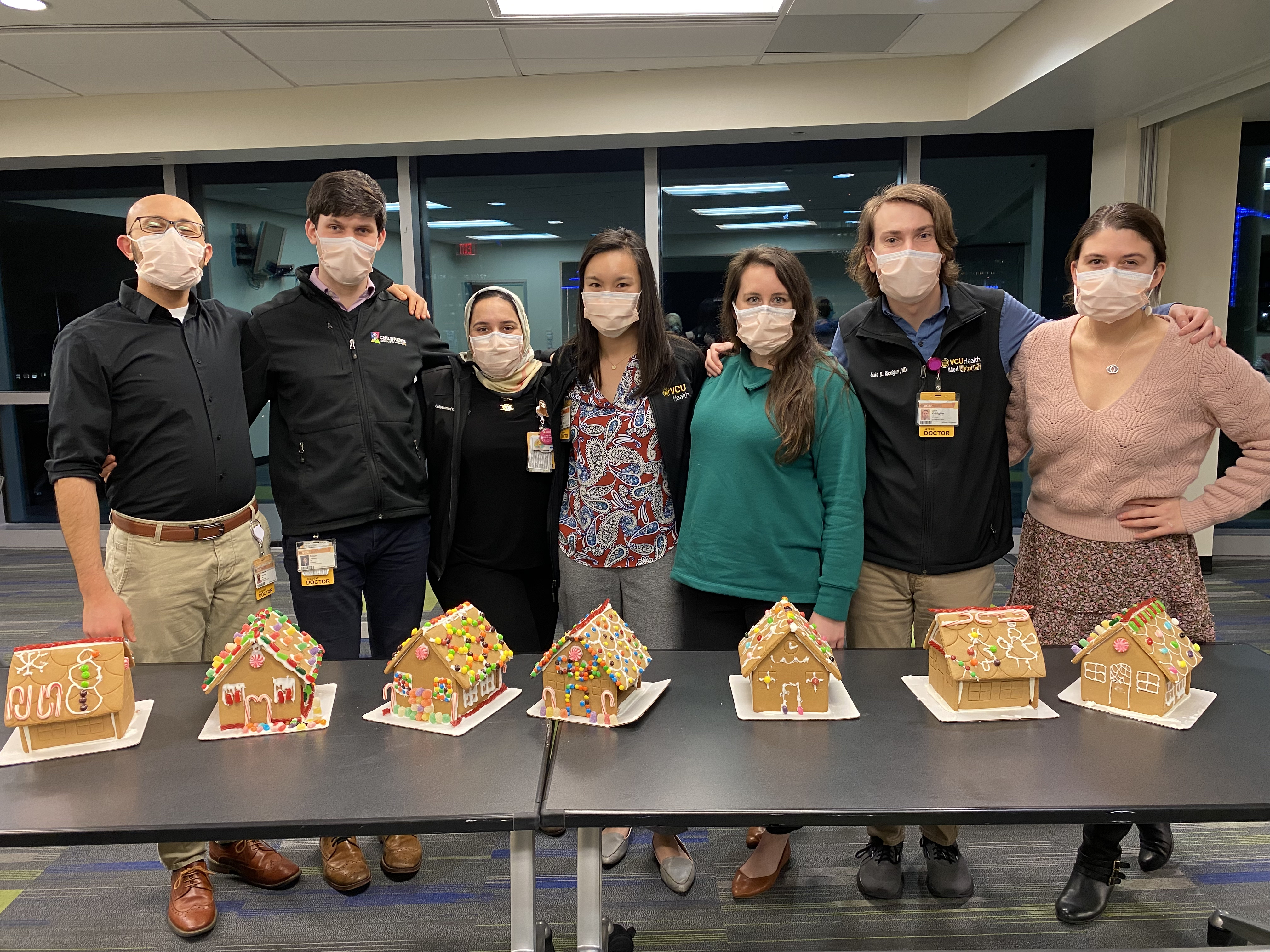 Residents posing for a photo with the gingerbread houses they decorated